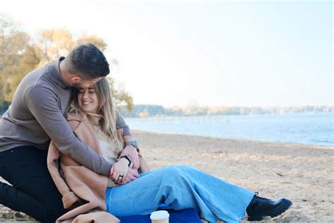 Date On The Beach In The Cold Season The Guy Hugs The Girl From Behind