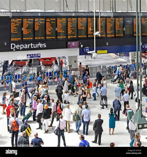 Commuters On Busy Waterloo Train Station Concourse With Departure Board