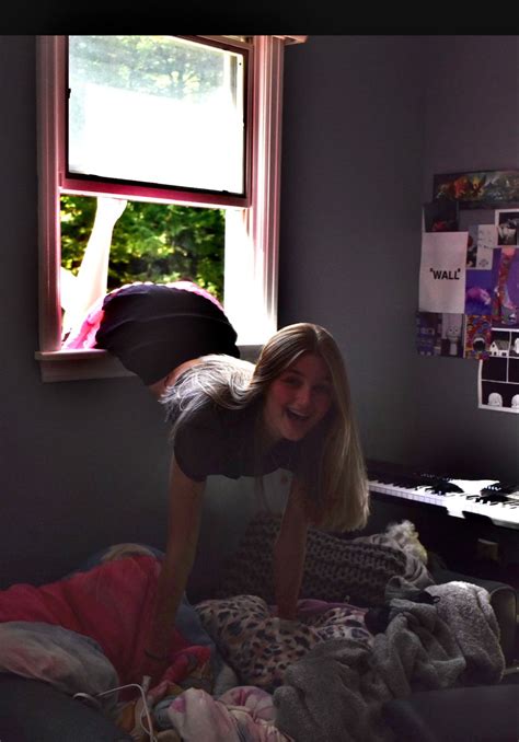 A Woman Is Laughing While Laying On Her Bed In Front Of A Window With