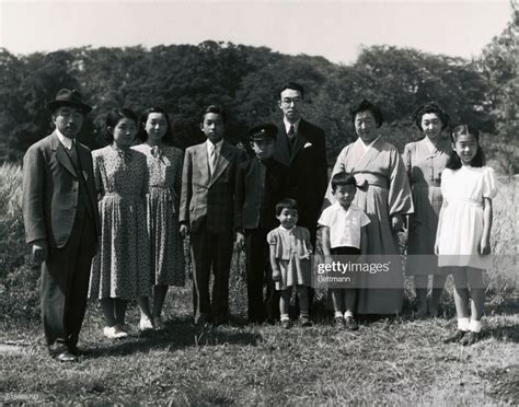 an old black and white photo of a family posing for a picture in the grass