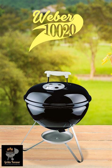 A Black Bbq Grill Sitting On Top Of A Wooden Table Next To A Green Field