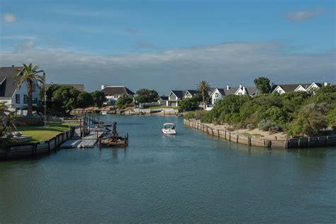 Scenic Riverfront with Residential Homes and BoatFree Stock Photo