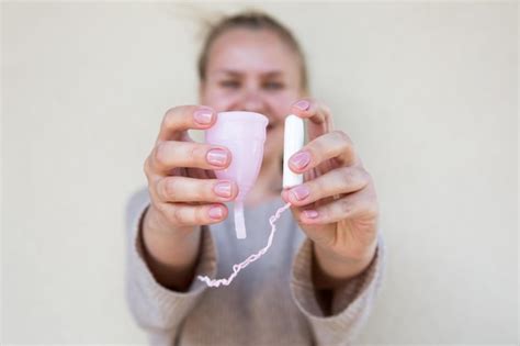 Tampón o copa menstrual la copa fem y el tampón sostienen una mano