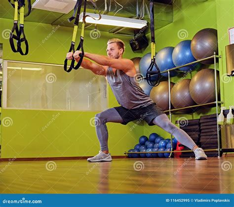 Blond Athletic Male Doing Trx Straps Exercises in a Gym Club. Stock ...