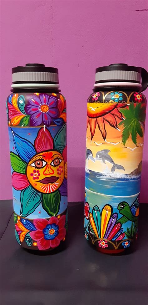 Two Colorful Vases Sitting Next To Each Other On A Black Table With