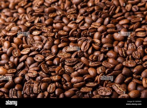 Brown coffee beans background closeup Stock Photo - Alamy