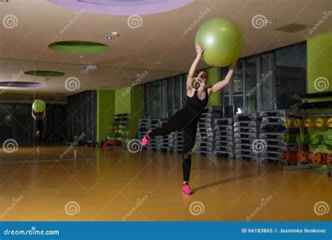 Mujer Que Se Resuelve Con La Bola En El Gimnasio Imagen De Archivo