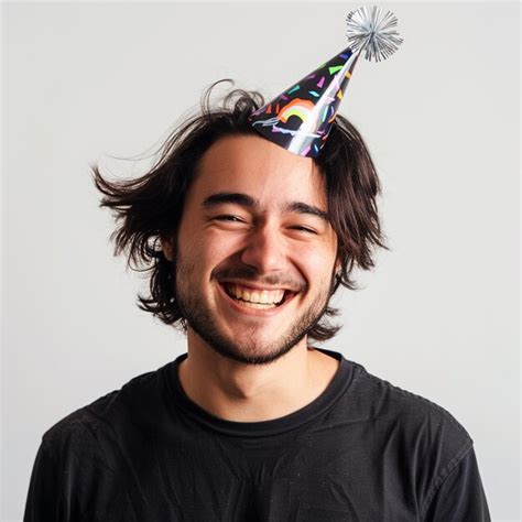 Smiling Guy Wearing A Party Hat On A White Background Premium Ai