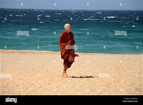 A Buddhist monk walks on a beach Stock Photo - Alamy