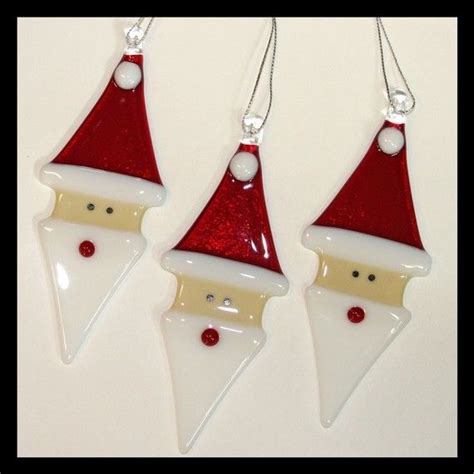 Three Christmas Ornaments With Santa Hats On Them