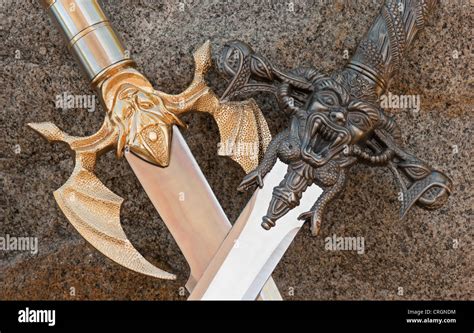 Medieval Design Crossed Sword Handles And Blades With Demons Closeup