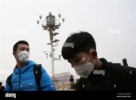 Tourists wearing face masks against air pollution visit the Tiananmen ...