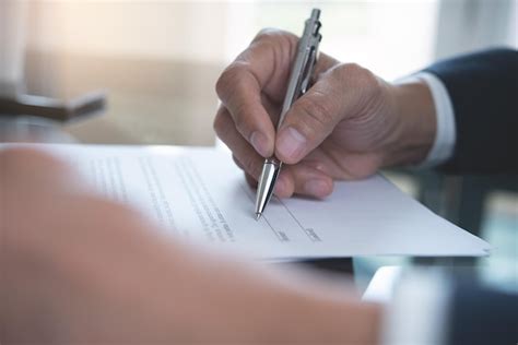 Homem de negócios assinando o documento formal do contrato oficial