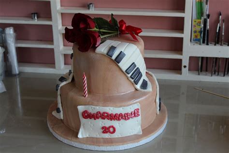 Two Tiered Cakes With Real Roses On Top And Piano Keys Draped Along