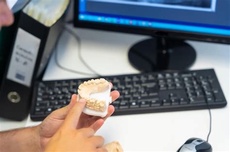 Detalhe do dentista da clínica odontológica explicando a um cliente os