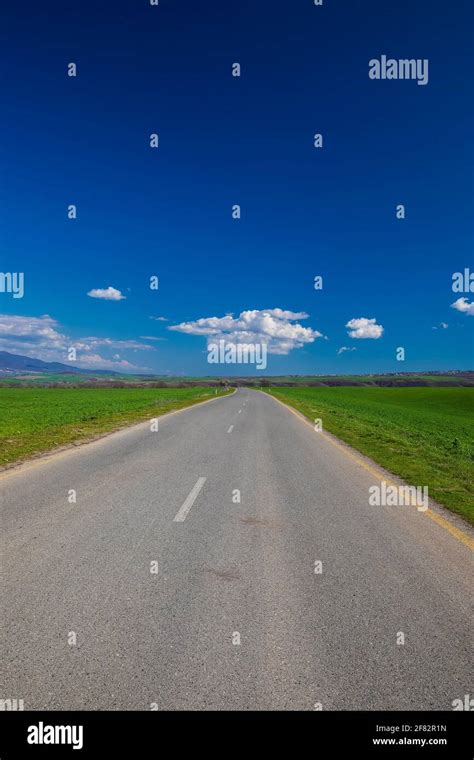 Asphalt Road Between Green Fields Stock Photo Alamy