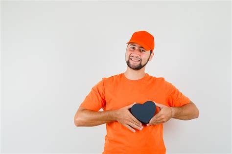 Free Photo Delivery Man Standing With Hands On Waist In Orange T