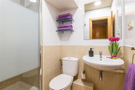 Premium Photo Cozy Bathroom With Toilet Sink And Mirror With Towels