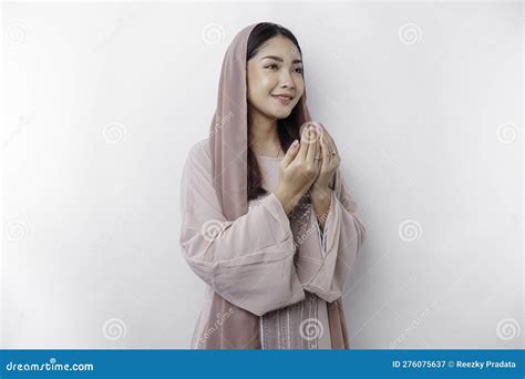 Religious Beautiful Asian Muslim Girl Wearing A Headscarf Praying To God Isolated By White