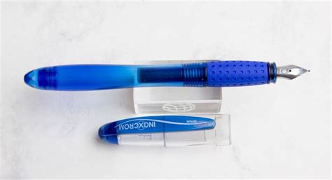 A Blue And White Pen Sitting On Top Of A Clear Box Next To It S Packaging