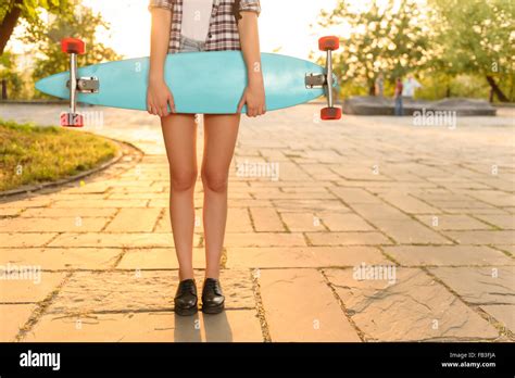 Overjoyed girl holding skateboard Stock Photo - Alamy