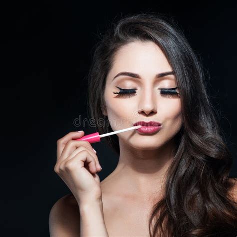 Portrait Of A Beautiful Young Woman Applied Lip Gloss Stock Photo