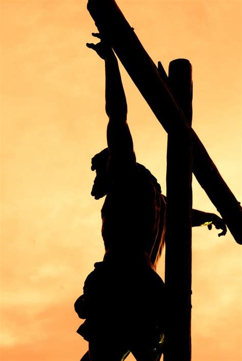 Cristo crucificado contra a luz durante o pôr do sol Foto Premium