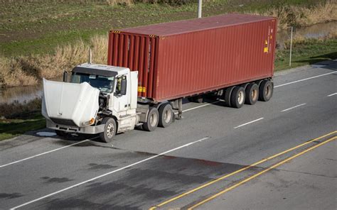 A Broken Semi Truck On The Side Of The Road With Its Hood Up