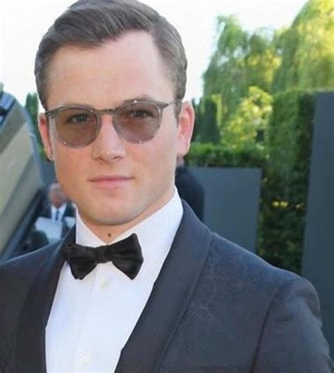 A Man In A Tuxedo And Bow Tie Is Posing For The Camera While Wearing Sunglasses