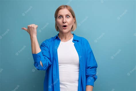 Premium Photo Surprised Blond Mature Woman In Disbelief On Blue