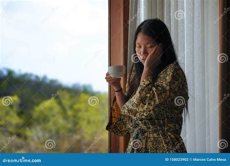 Lifestyle Portrait Of Young Beautiful Happy And Relaxed Asian Chinese Woman In Stylish Bathrobe