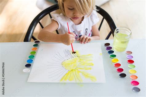 Child painting sun with watercolors Stock Photo | Adobe Stock