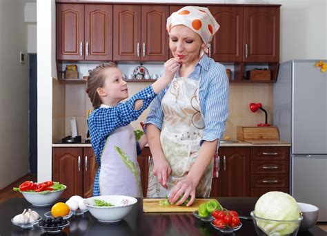 La Hija Ayuda A La Madre A Preparar La Comida En Casa Foto Premium