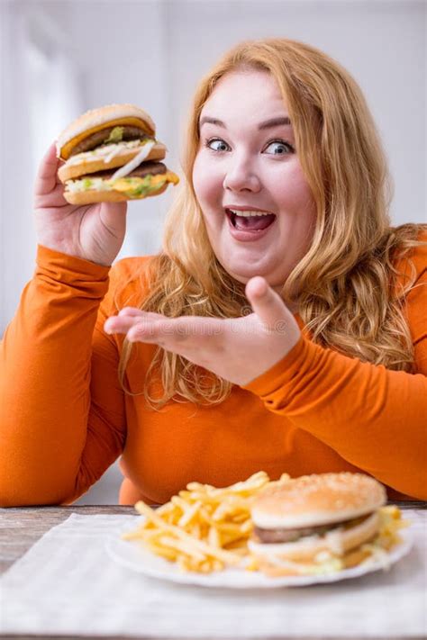 Grosse Femme Vigilante Mangeant Des Fritures Et Des Sandwichs Photo