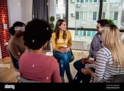 Diverse Group Of People Sitting In Circle In Group Therapy Session