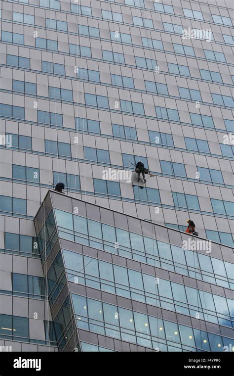 Workers are cleaning windows outside office building Stock Photo - Alamy