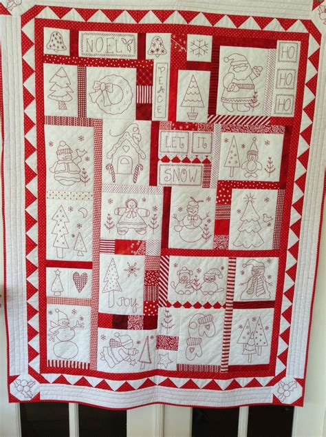 A Red And White Christmas Quilt Hanging On A Door