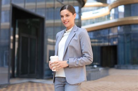 Retrato de mujer de negocios exitosa que va a trabajar con café