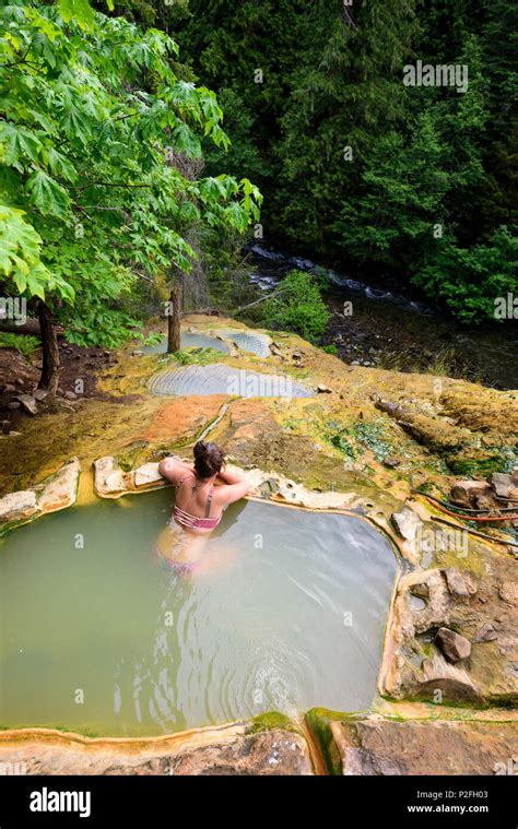 A Woman Relaxes In The Scenic Umpqua Hot Springs In The Mountains Above