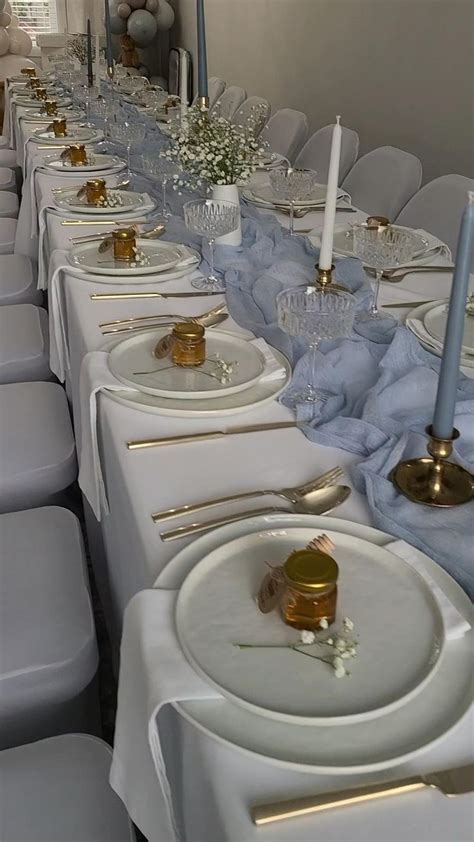 A Long Table Is Set Up With White Plates And Silverware For An Elegant