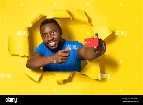 Positive Black Man Holding Credit Bank Card Isolated Through Torn