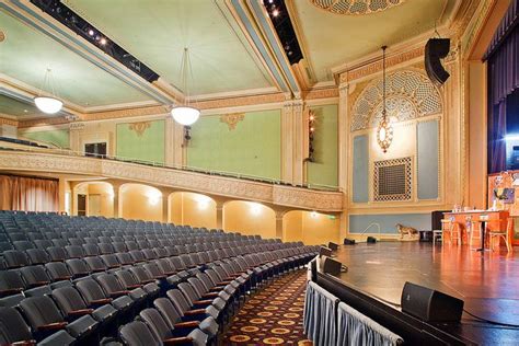 An Empty Auditorium With Rows Of Seats In Front Of The Stage And Lights