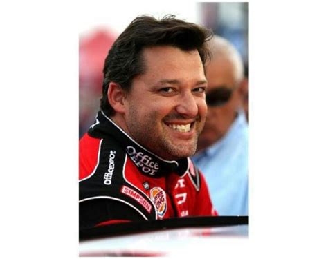 A Smiling Man In A Red And Black Outfit