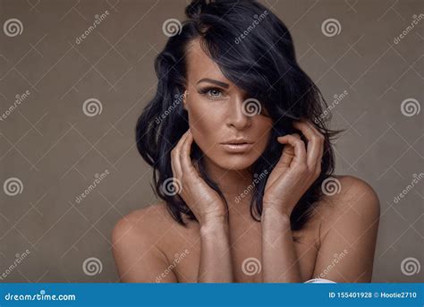 Beautiful Middle Aged Brunette Woman With Her Hair Swept Over One Eye