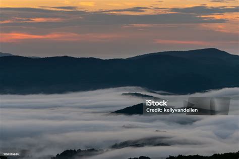 Pink Morning Light In Sky With Mountain Island Through Clouds Stock