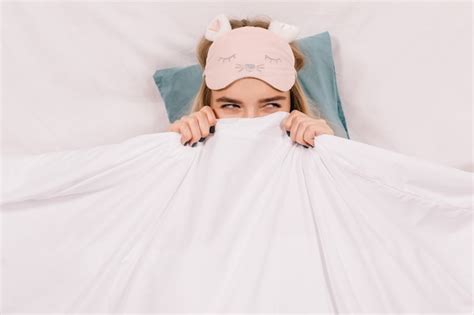 Adorable Femme En Masque De Sommeil Posant Dans Son Lit Photo Gratuite