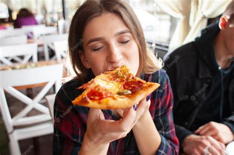 Premium Photo Young Girl Eating A Slice Of Pizza Indoors Girl Student