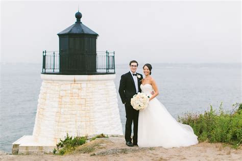 A Bride And Groom Standing In Front Of A Lighthouse