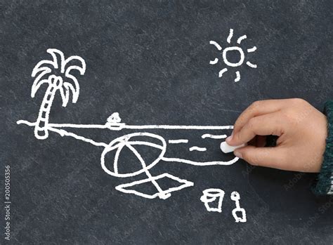 Enfant dessinant une plage à la craie sur une ardoise Stock Photo