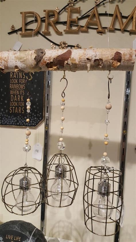 Three Birdcages Hanging From A Tree Branch With Beads And Chains